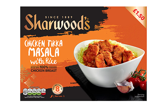 Front of pack image for Sharwoods frozen curry ready meals, featuring a food photograph of chicken jalfrezi with rice served in a white bowl on a slate slab