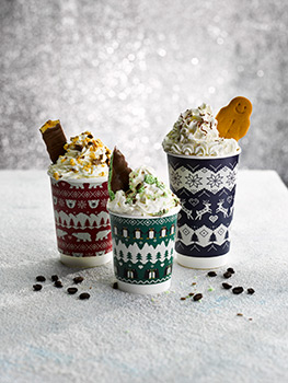 Food photograph of three festive takeaway coffee recipes, gingerbread, mint and honeycomb coffees, all topped with whipped cream shot on glittering backgrounds